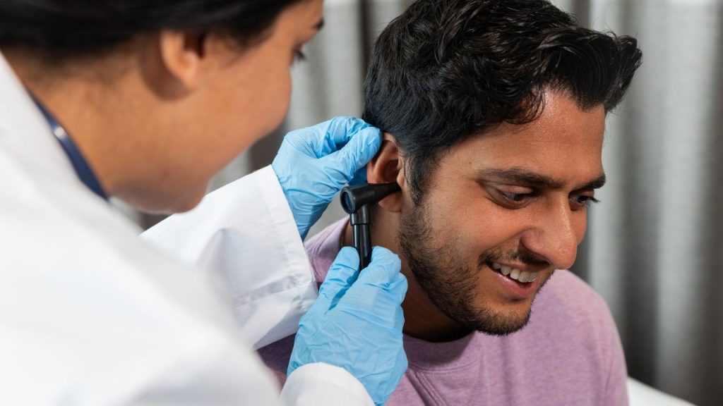 ENT doctor performing ear checkup using otoscope